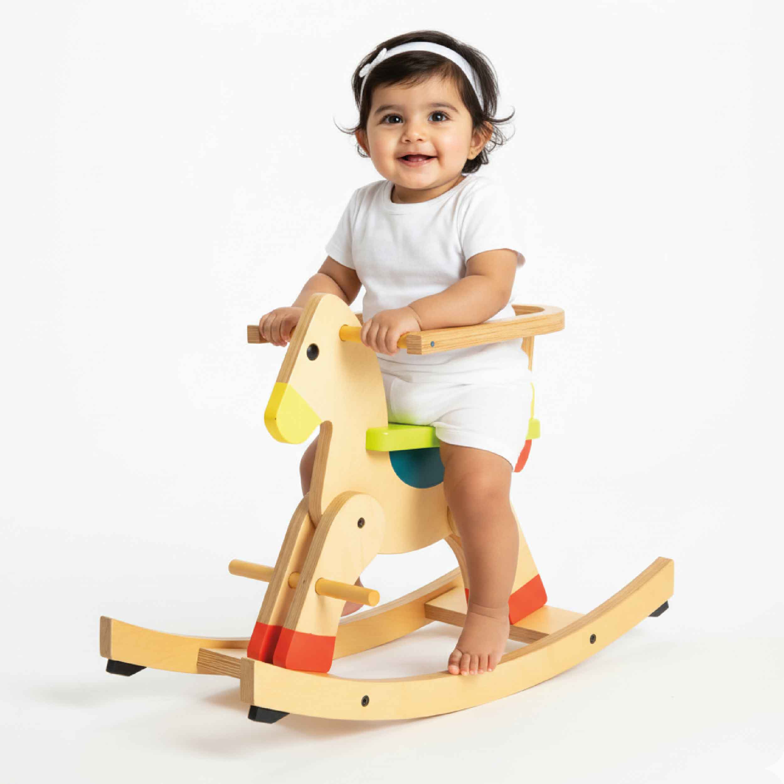 Toddler seated on wooden rocking horse