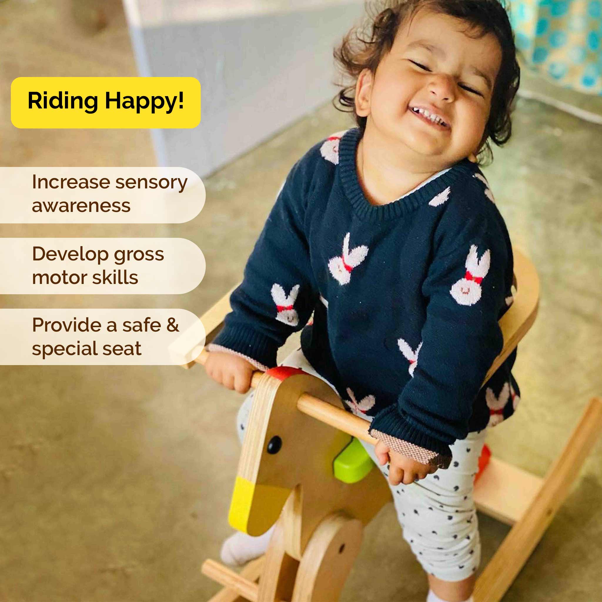 Toddler enjoying wooden rocking horse